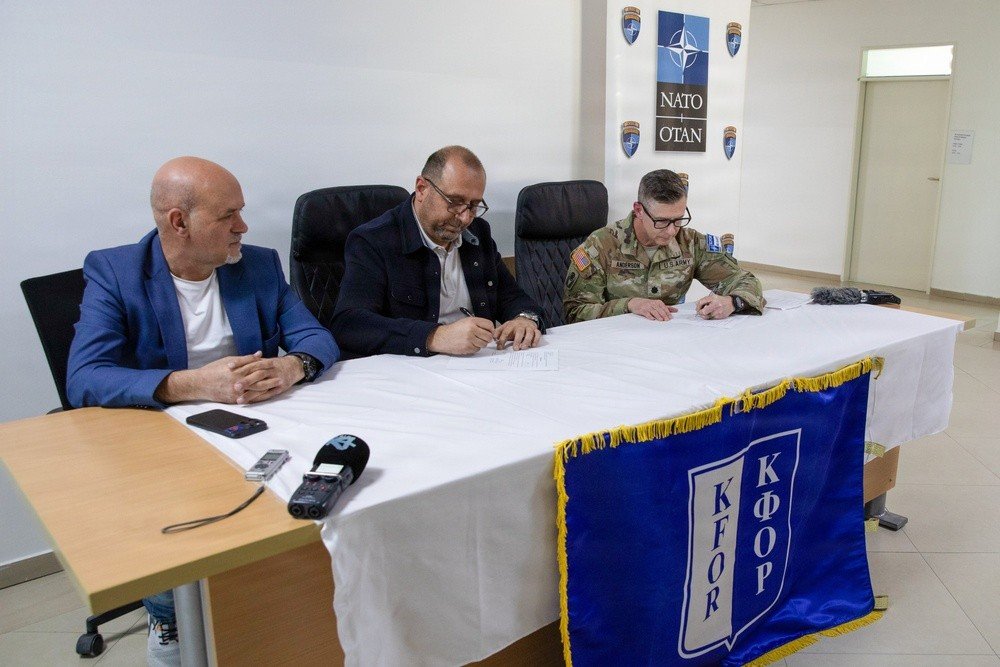 Подполковник Майкл Андерсон (KFOR RC-East) и заместитель мэра Приштины Флориан Души подписывают документы о передаче больничных кроватей