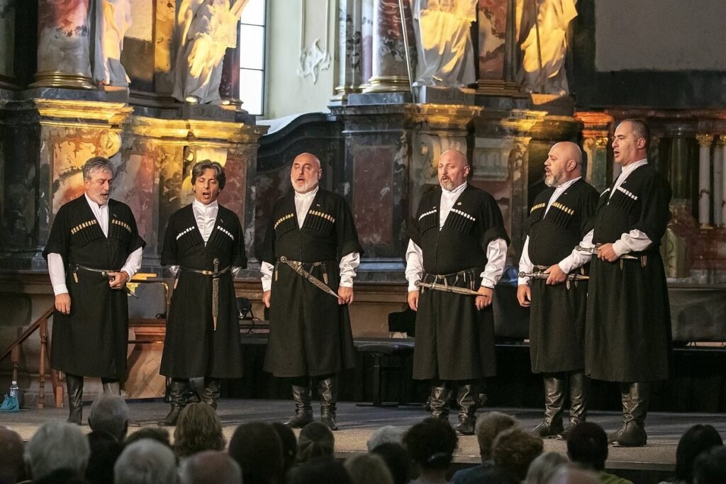 Грузинский ансамбль «Сулико» едет с концертами в Литву Шесть грузинских певцов в традиционных чёрных чохах на сцене церкви