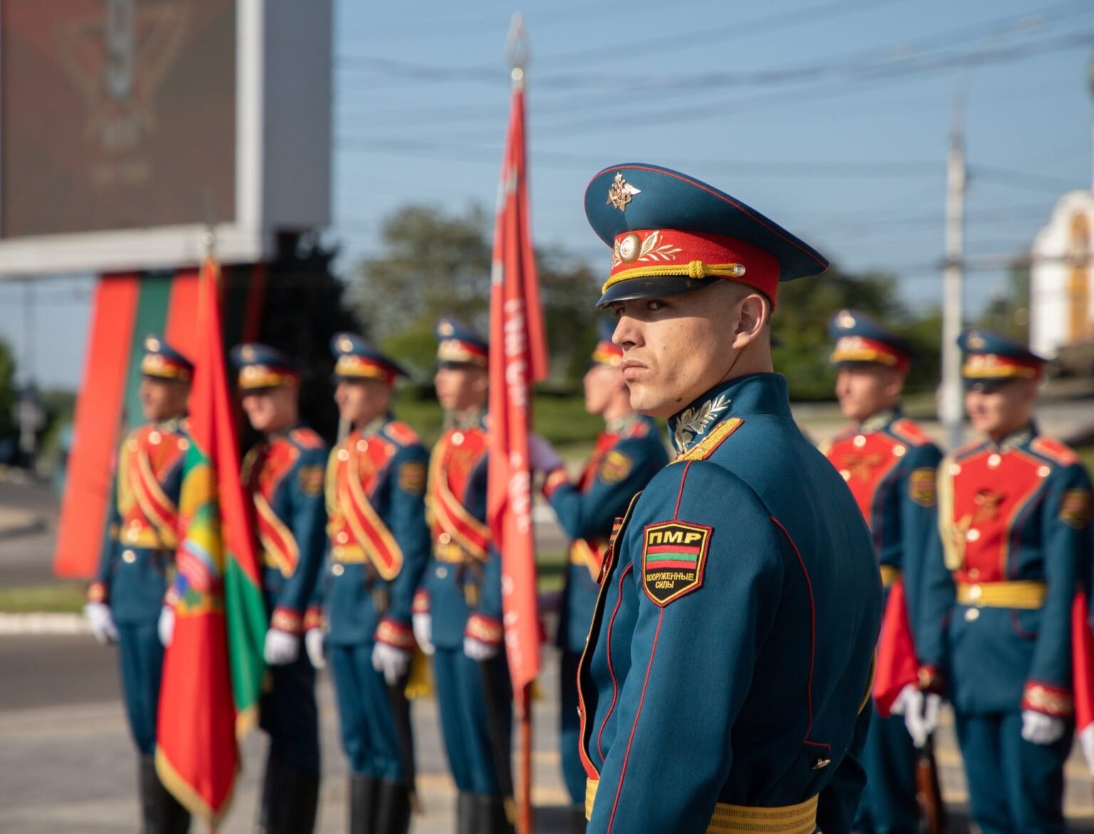 Transnistria (PMR) military parade with soldiers in ceremonial uniforms holding flags. Фото: CEPA