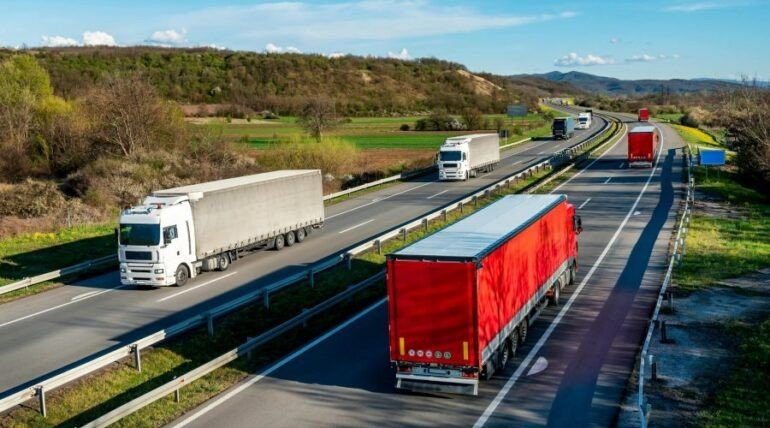 Зарплаты водителей фур в Албании догнали Грецию — €2 500 в месяц Грузовые фуры движутся по многополосной автомагистрали на фоне зелёных холмов