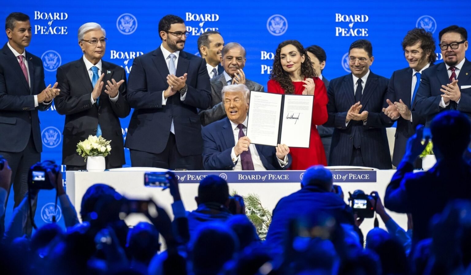 Дональд Трамп демонстрирует подписанный устав Совета мира на церемонии подписания в окружении мировых лидеров