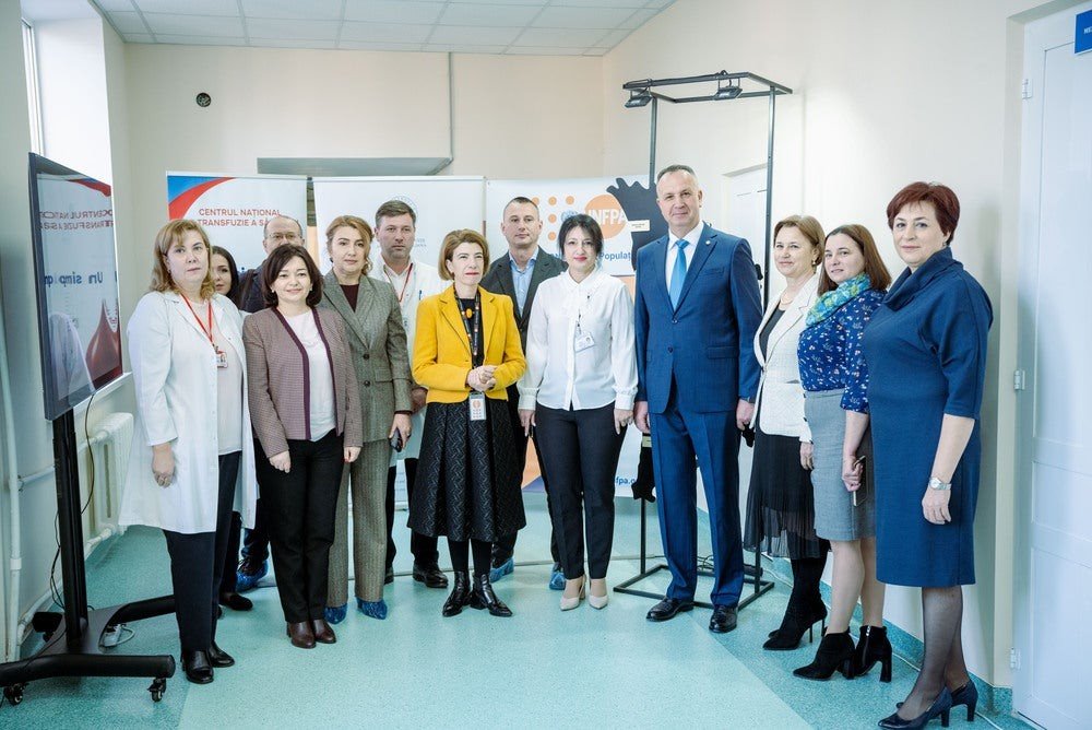 Группа официальных лиц и медицинского персонала в Национальном центре трансфузии крови Молдовы во время мероприятия ЮНФПА, посвящённого охране здоровья матерей и новорождённых