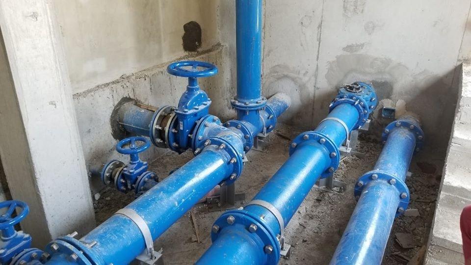 Синие водопроводные трубы и задвижки на насосной станции албанского водоканала