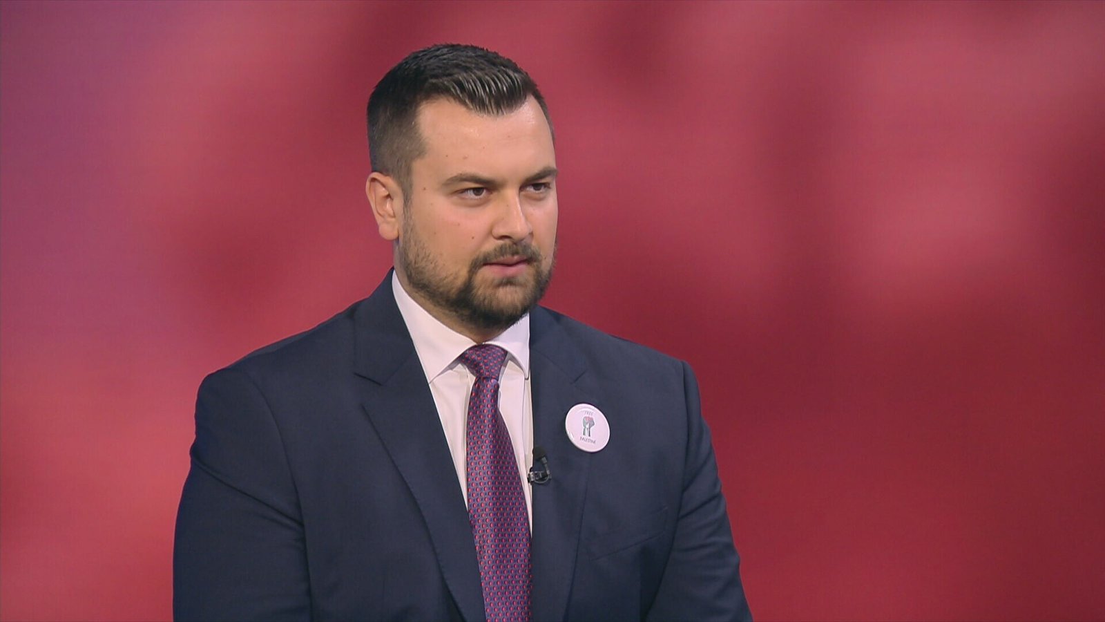 Армин Ходжич во время интервью на телеканале Dnevnik в тёмном костюме с бейджем. Фото: Dnevnik.hr