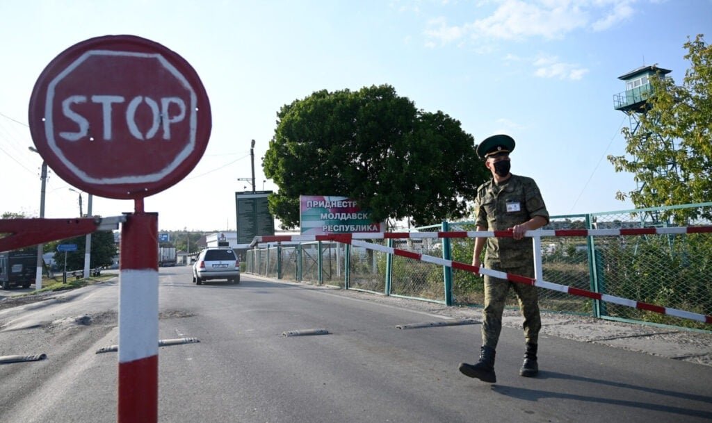 Transnistria checkpoint with soldier in camouflage near STOP sign and Pridnestrovian Moldavian Republic sign. Фото: Timpul.md