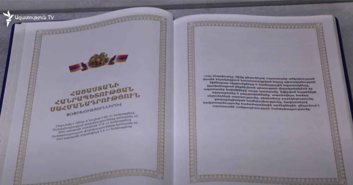 Конституция Республики Армения — раскрытая книга с официальным гербом и текстом основного закона страны