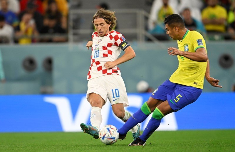 Лука Модрич ведёт мяч в матче сборной Хорватии, обыгрывая соперника на переполненном стадионе