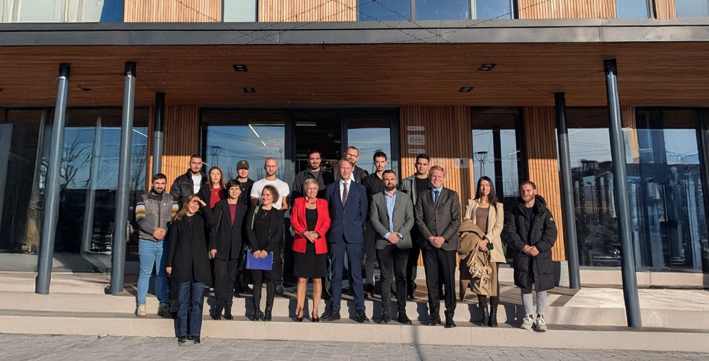 Члены ассоциации STIKK на групповом фото у современного здания в Косово