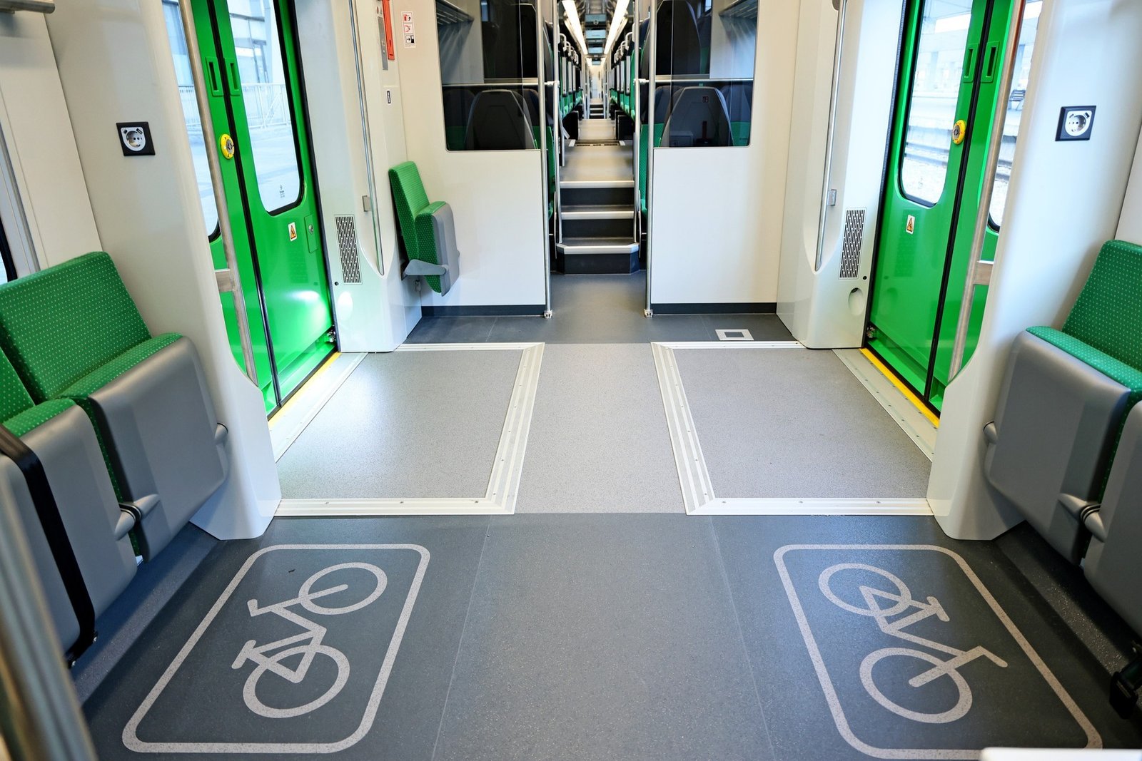Интерьер нового электропоезда Škoda: просторная зона для велосипедов с низким полом и современными зелёными сиденьями