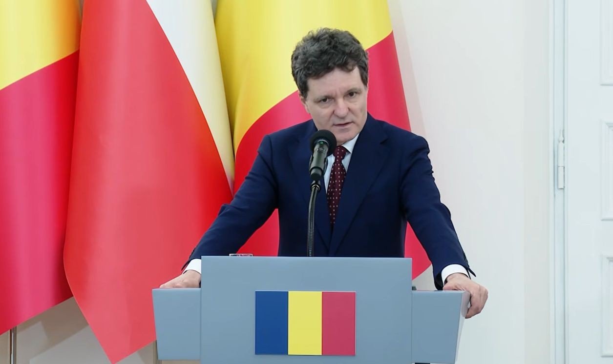 Romanian President Nicusor Dan speaking at podium with Romanian flag. Фото: HotNews.ro