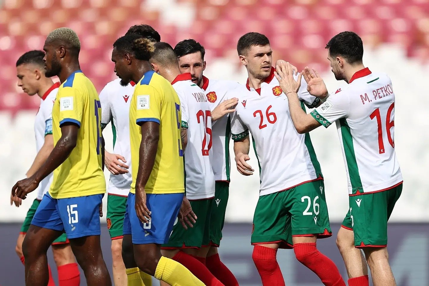 Игроки сборной Болгарии под номерами 26 и 16 (М. Петков) поздравляют друг друга после забитого гола, в то время как футболисты Соломоновых Островов уходят с опущенными головами