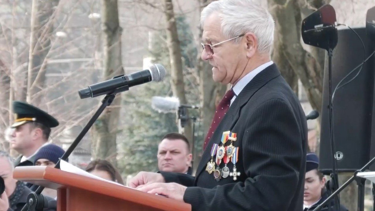 Elderly veteran with military medals speaking at podium during memorial ceremony. Фото: Radio Moldova