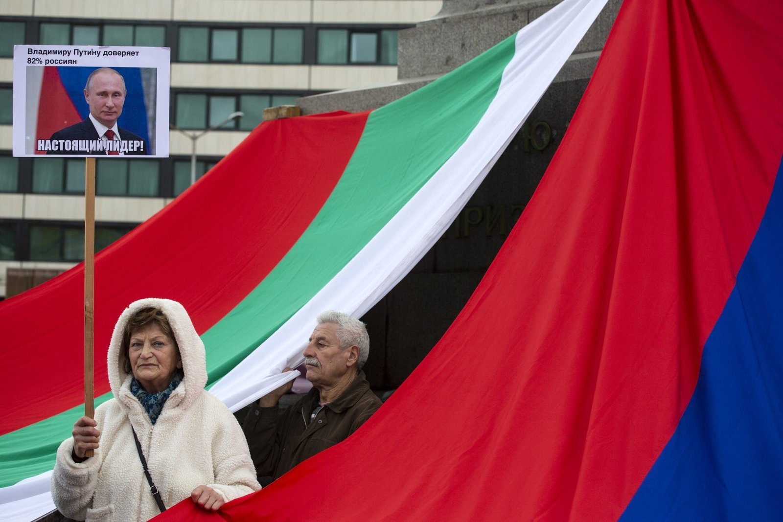 Пророссийский протест в Болгарии с болгарскими и российскими флагами, женщина с плакатом в поддержку Путина. Фото: DFRLab (Atlantic Council)