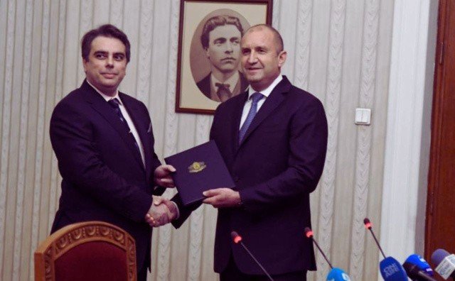 Асен Василев и Румен Радев обмениваются рукопожатием на официальной встрече в президентской администрации на фоне портрета Васила Левского