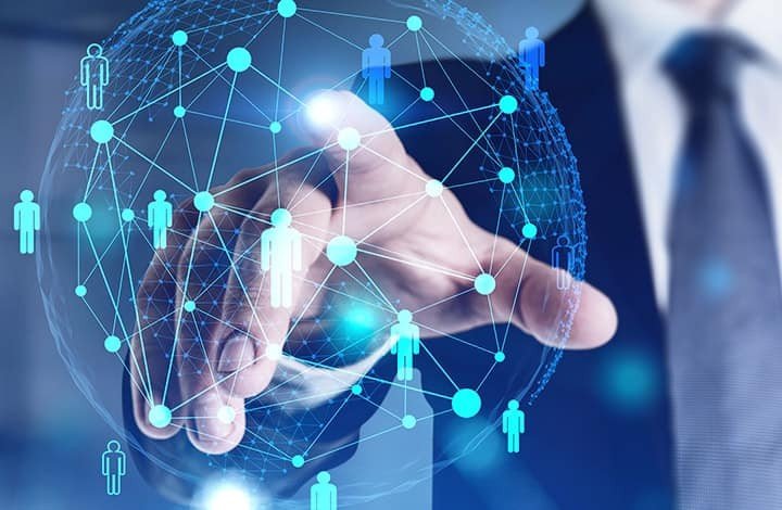 Бизнесмен докосва дигитална мрежа от свързани човешки фигури, символизираща глобалната технологична свързаност. Илюстрация: Banker.bg