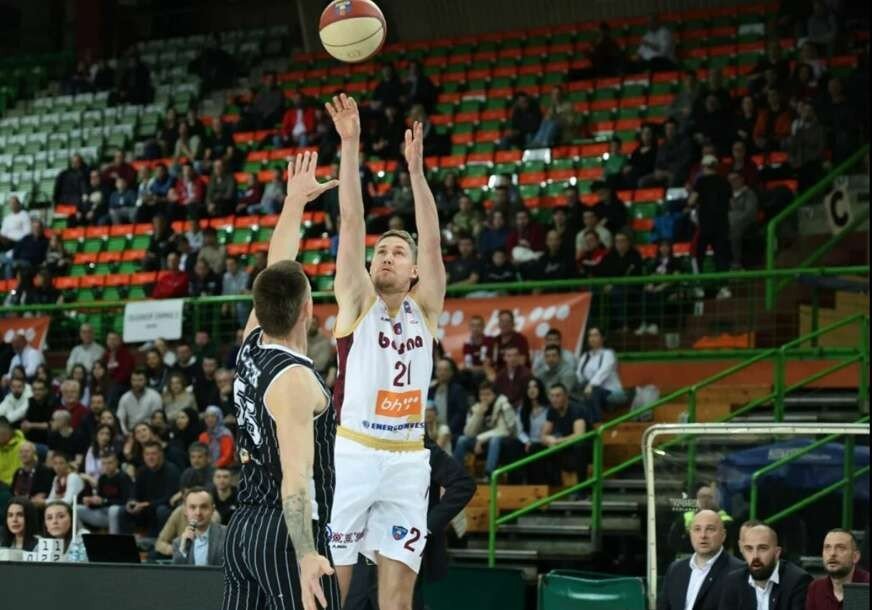 Баскетболист «Босны» №21 выполняет бросок через защитника У-БТ Клуж на фоне заполненных трибун зала «Зетра»