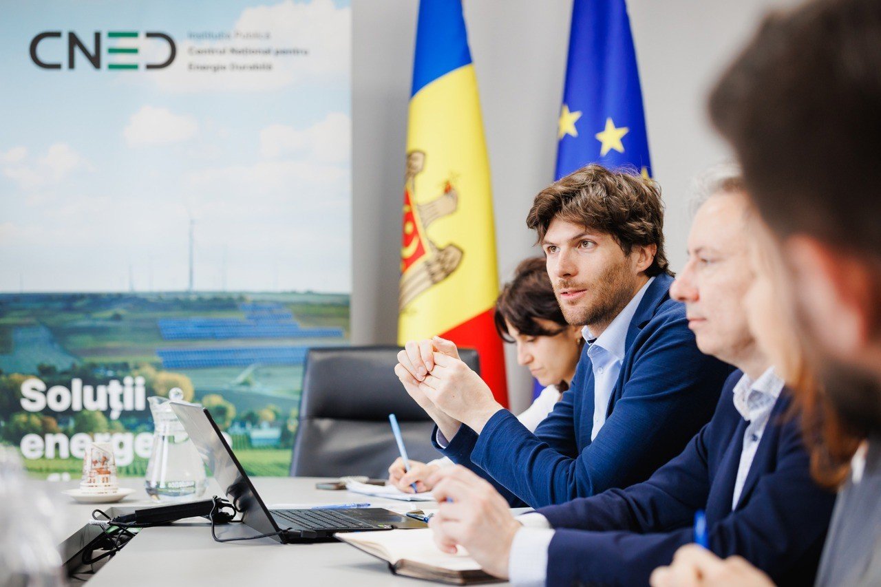 Представители Национального центра устойчивой энергетики (CNED) обсуждают энергетическую политику на фоне флагов Молдовы и ЕС