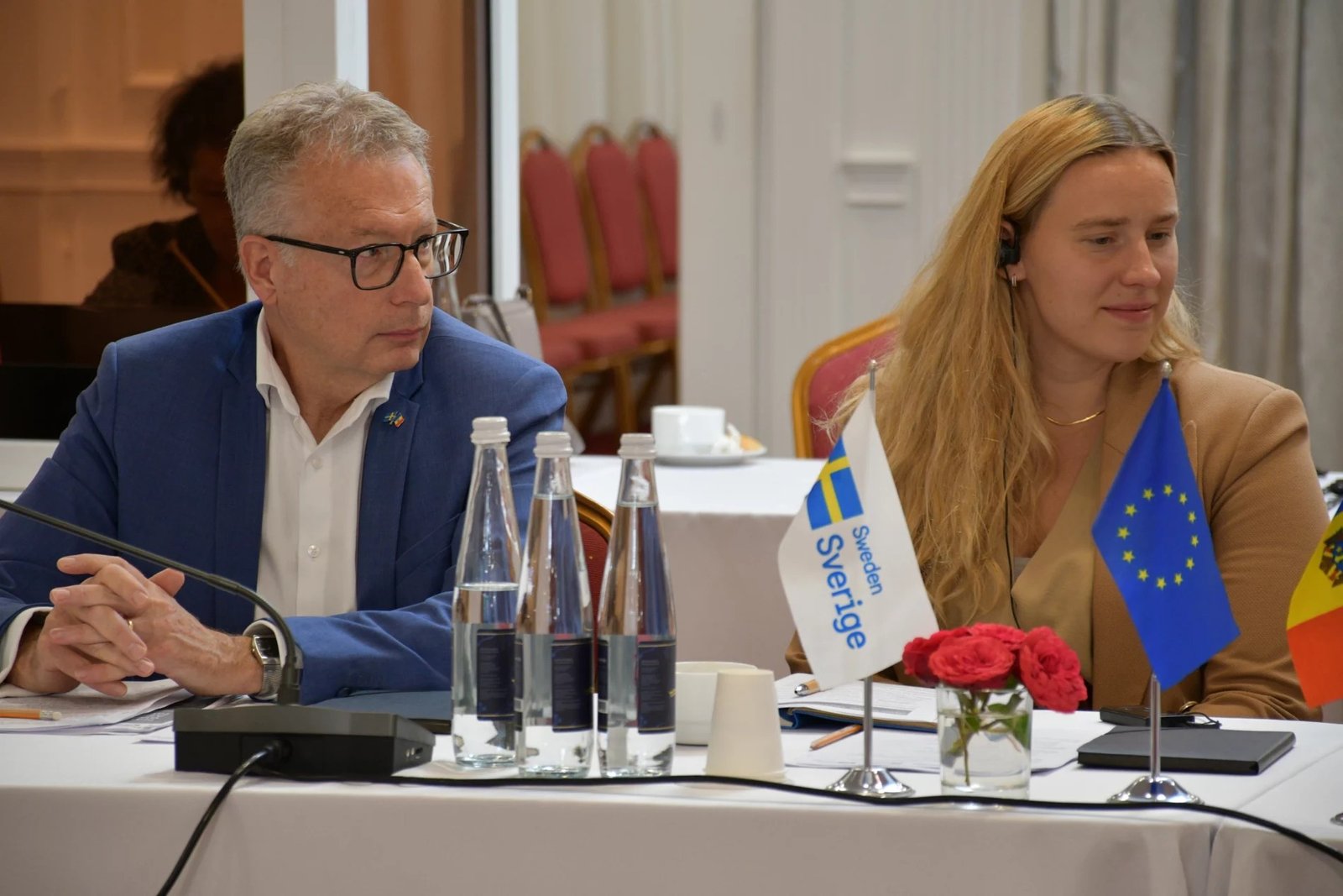 Шведские и европейские делегаты за столом переговоров с флагами Швеции, ЕС и Молдовы во время обсуждения зелёного перехода