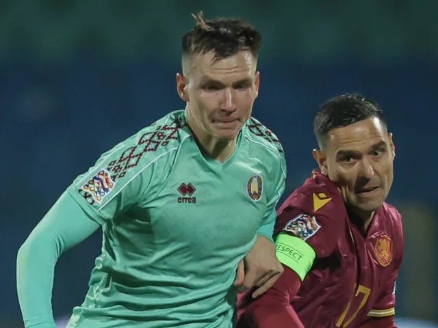 Валерий Бочеров из сборной Беларуси в борьбе за мяч с соперником