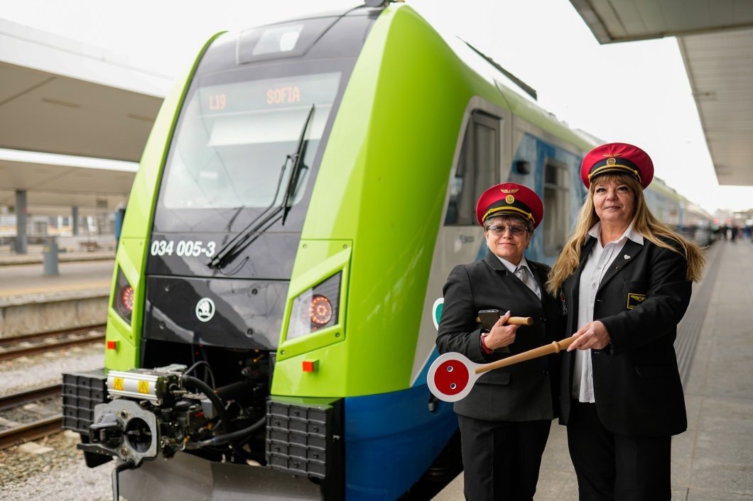 Две болгарские проводницы позируют на фоне нового электропоезда Škoda RegioPanter с табло маршрута «София» на вокзале