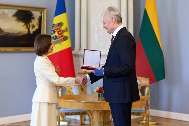 Санду передаёт Науседе Орден Республики с рукопожатием в парадном зале президентского дворца