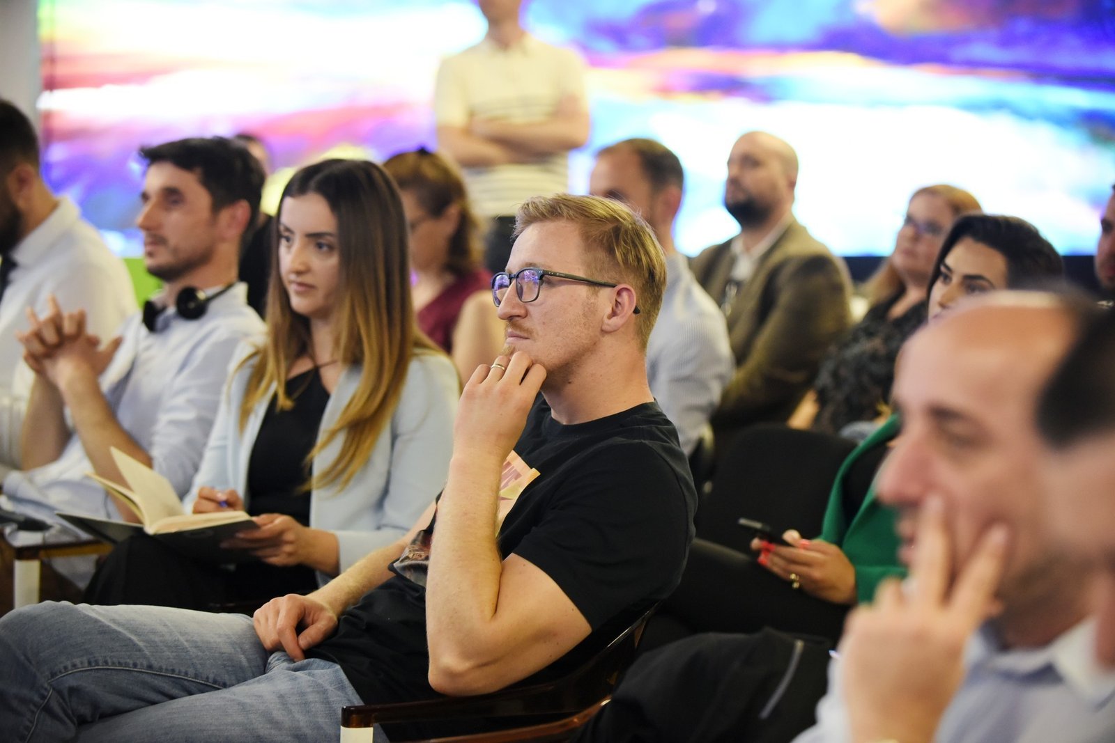 Молодые специалисты в зале на технологическом мероприятии в Косово