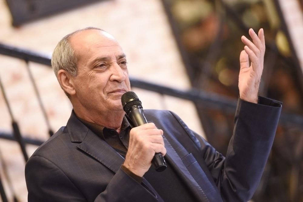 Расим Балаев с микрофоном в руке на творческом вечере