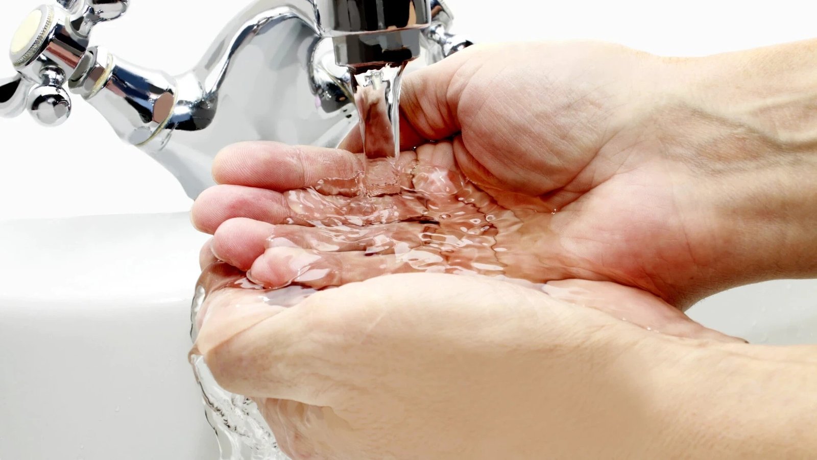 Питьевая вода течёт из крана в подставленные ладони