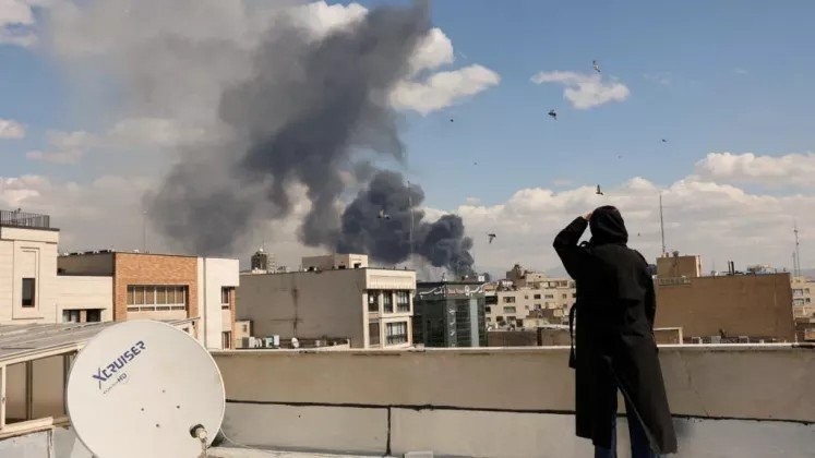 Столб дыма над городом на Ближнем Востоке, вид с крыши здания. Фото: Newsmaker