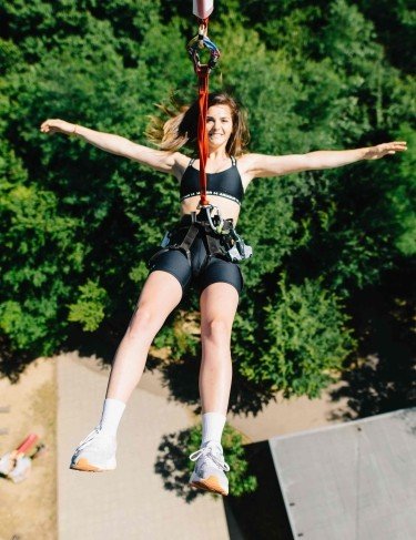 Посетительница совершает прыжок на аттракционе PowerFan Jump в парке Arsenal Park