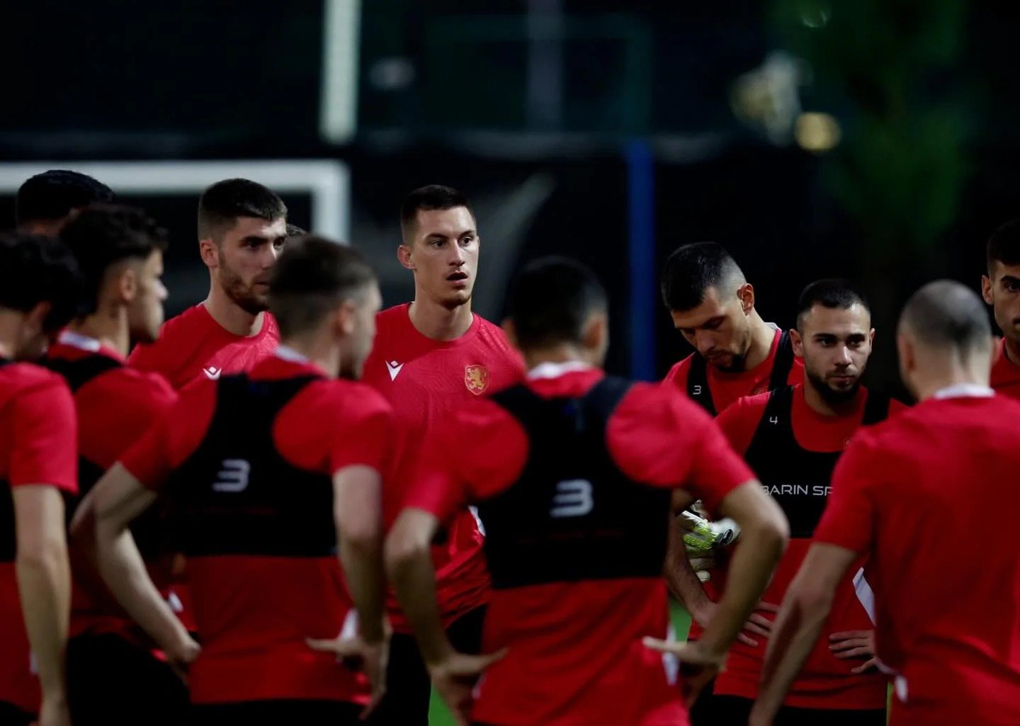 Группа игроков сборной Болгарии в красных тренировочных футболках крупным планом