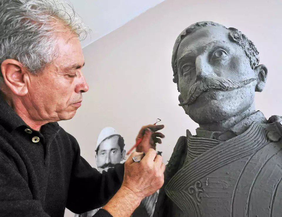 Из горной Албании — в Белый дом: путь скульптора Ракая Скульптор Васил Ракай работает над глиняным бюстом исторического персонажа в своей мастерской, на стене — архивная фотография-образец