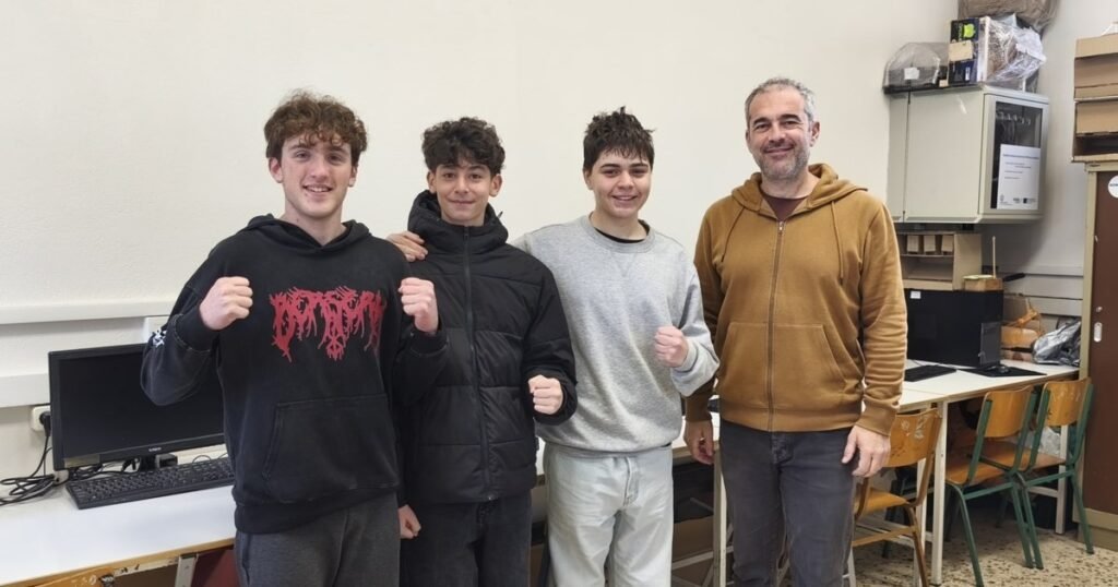 Школьники Греции создают устройства для цифрового здоровья Трое учеников 1-й образцовой гимназии Митилини и их учитель позируют в классе после победы на конкурсе Generation Next с проектом Micro-Posture