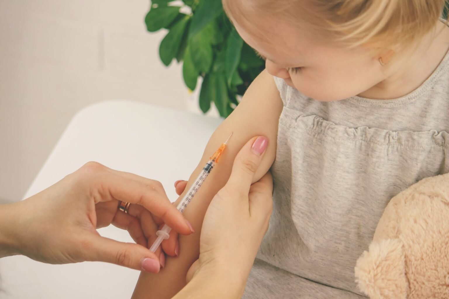Маленькому ребёнку делают прививку в медицинском кабинете
