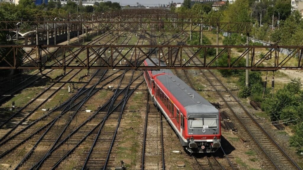 Электропоезд движется по электрифицированным железнодорожным путям с контактной сетью, вид сверху