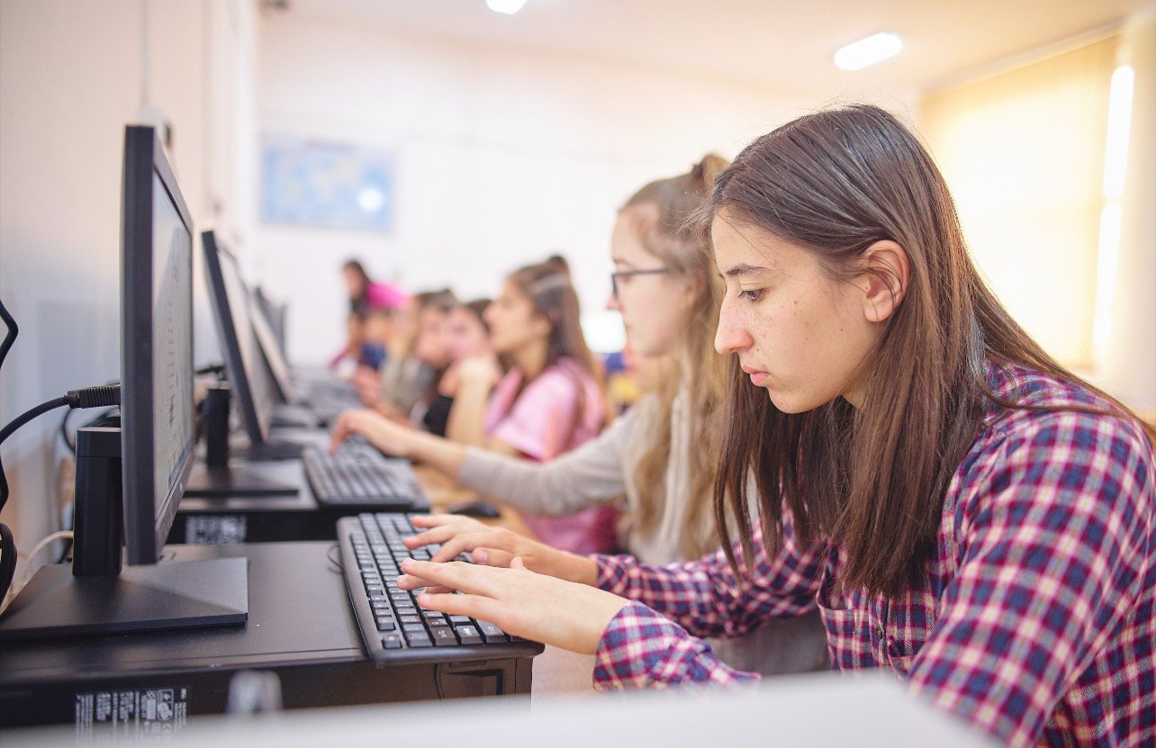 Подростки работают за компьютерами в классе, демонстрируя цифровую вовлеченность молодежи. Фото: Revista Biz