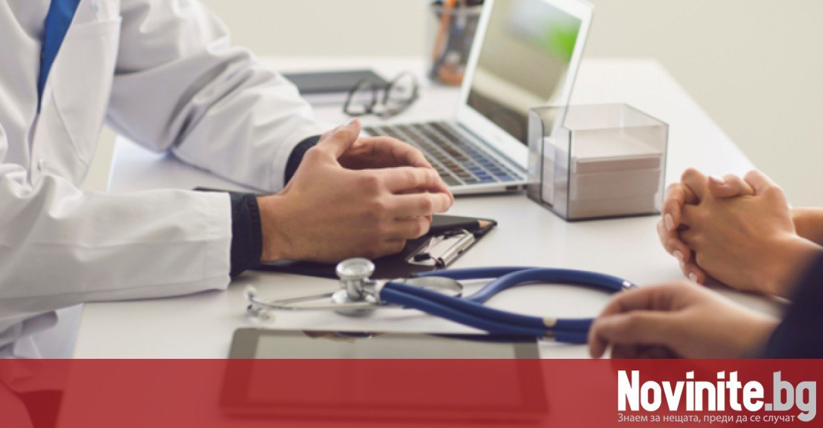 Врач за рабочим столом на консультации с пациентом, на столе стетоскоп и ноутбук