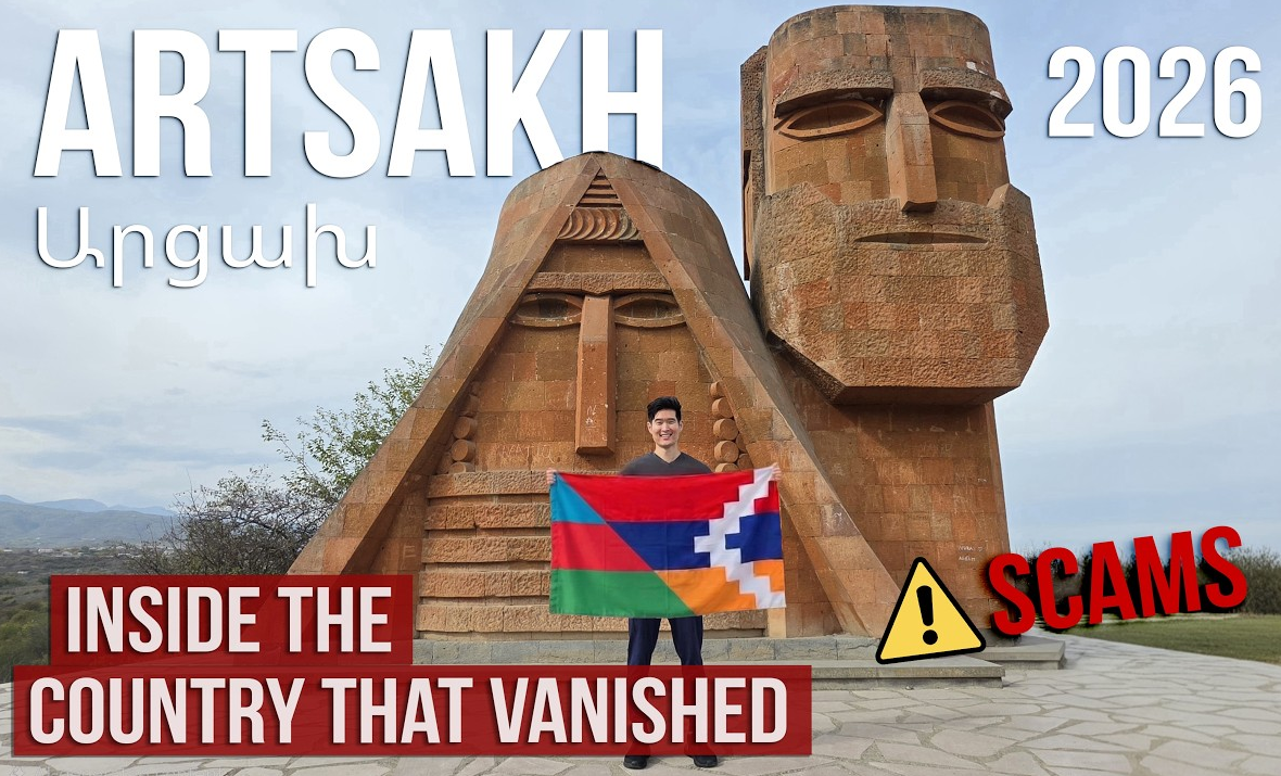 Корейский блогер YoungMin Skies с флагом Арцаха на фоне монумента «Мы — наши горы» в Степанакерте