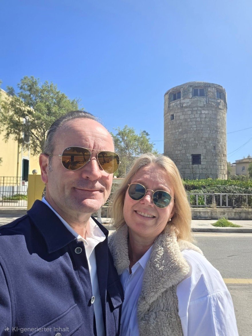 Немецкая пара позирует у каменной башни на острове Родос в солнечный день