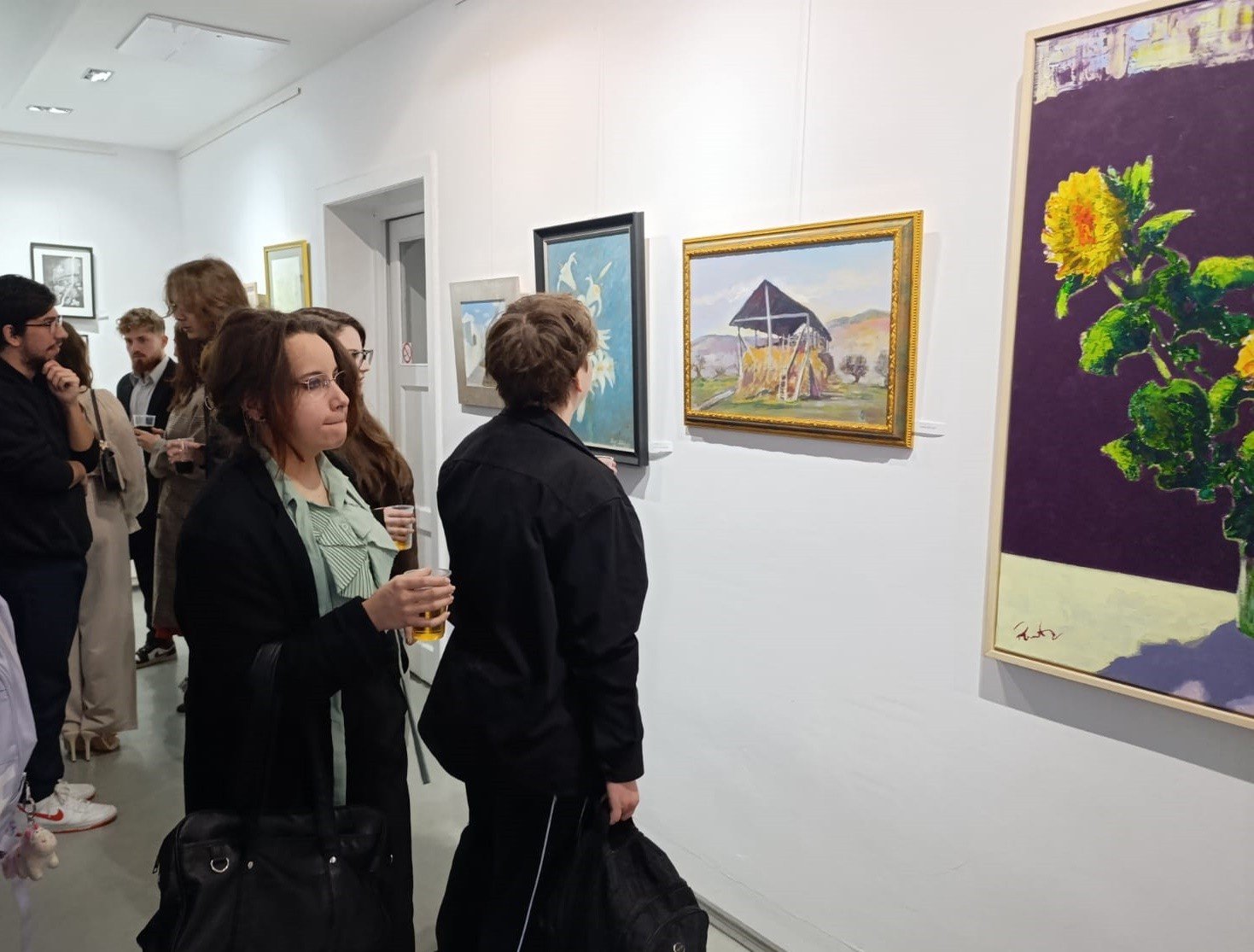 Посетители рассматривают картины на вернисаже ежегодного салона филиала UAPR в Галерее Николае Манту в Галаце