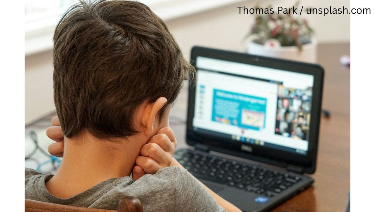 Мальчик сидит за ноутбуком, просматривая интернет без присмотра взрослых