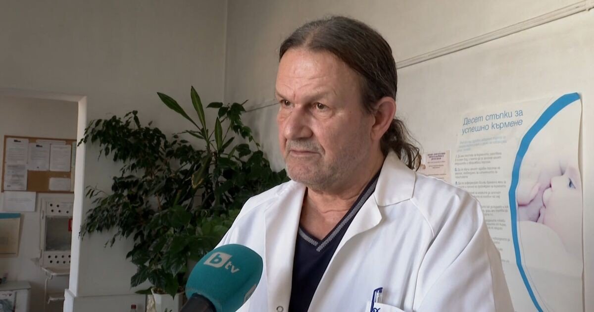 Врач в белом халате даёт интервью телеканалу bTV в больничном кабинете на фоне плаката о грудном вскармливании