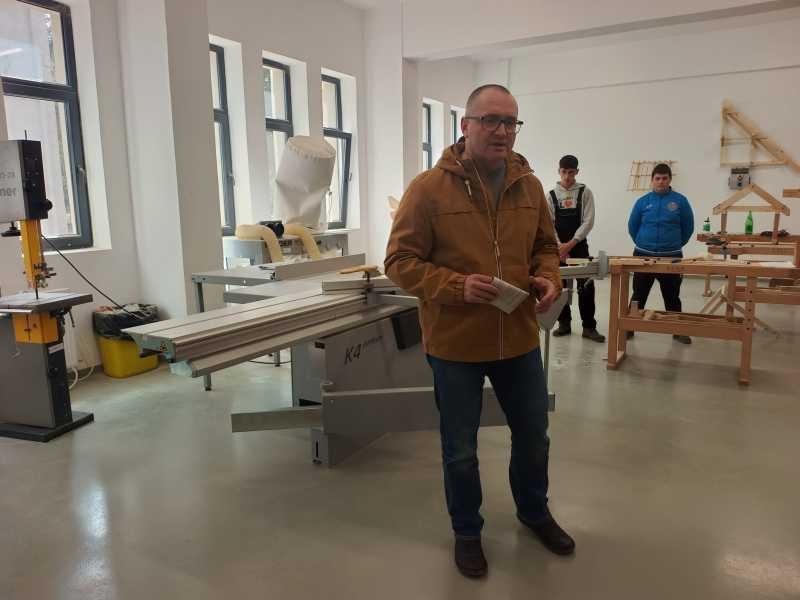 Представитель мэрии Меркуря-Чук рассказывает о новом промышленном оборудовании в мастерской лицея, оснащённой в рамках Национального плана восстановления