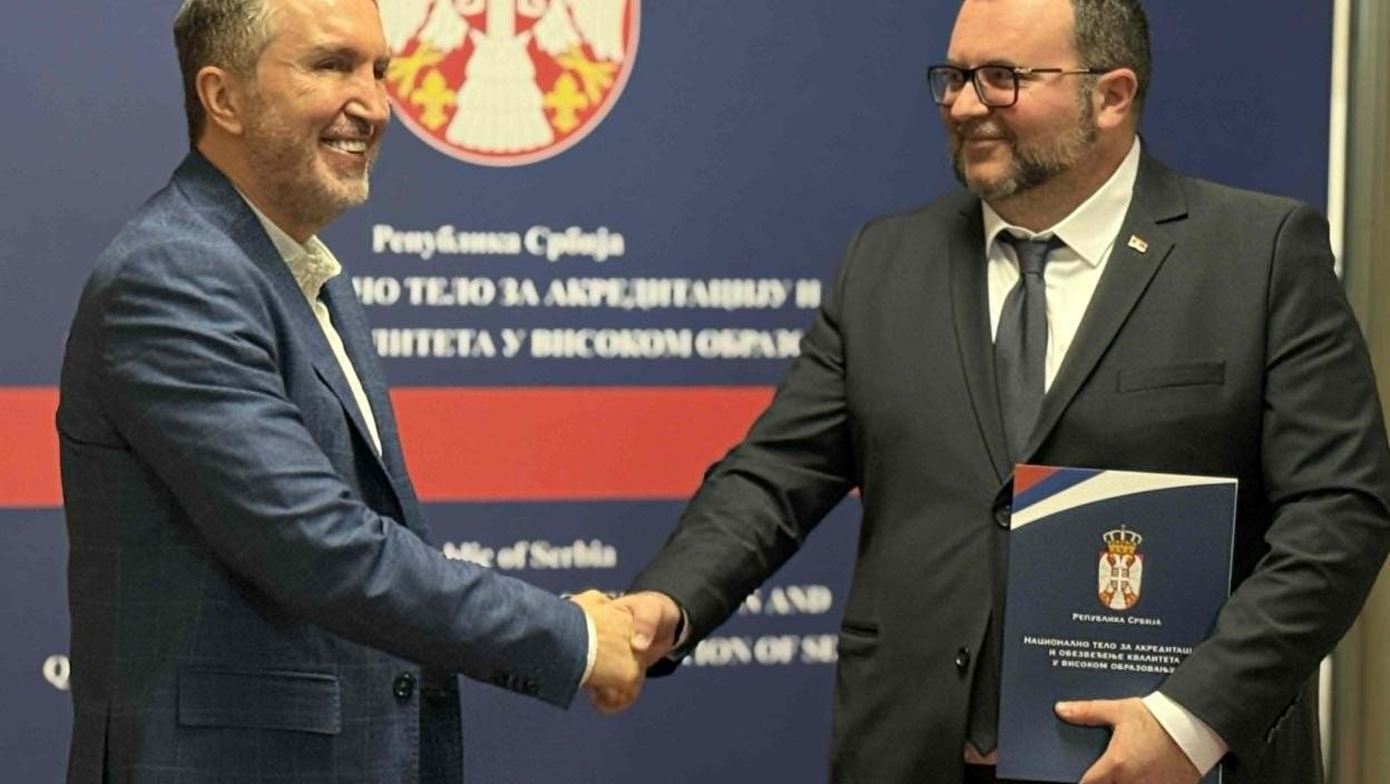 Вручение документа о начальной аккредитации Факультета сербских исследований Университета в Нише на фоне баннера Национального аккредитационного органа