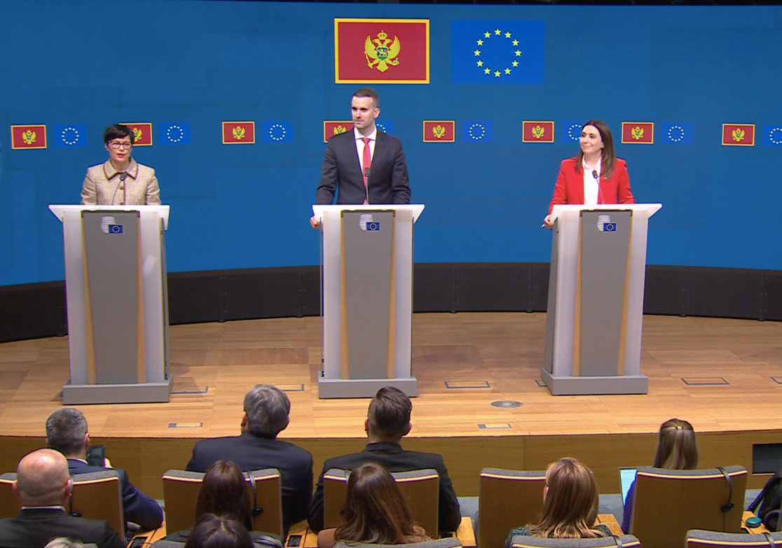 Пресс-конференция ЕС с тремя официальными лицами на трибунах, флаги Черногории и ЕС, обсуждение закрытия Главы 32