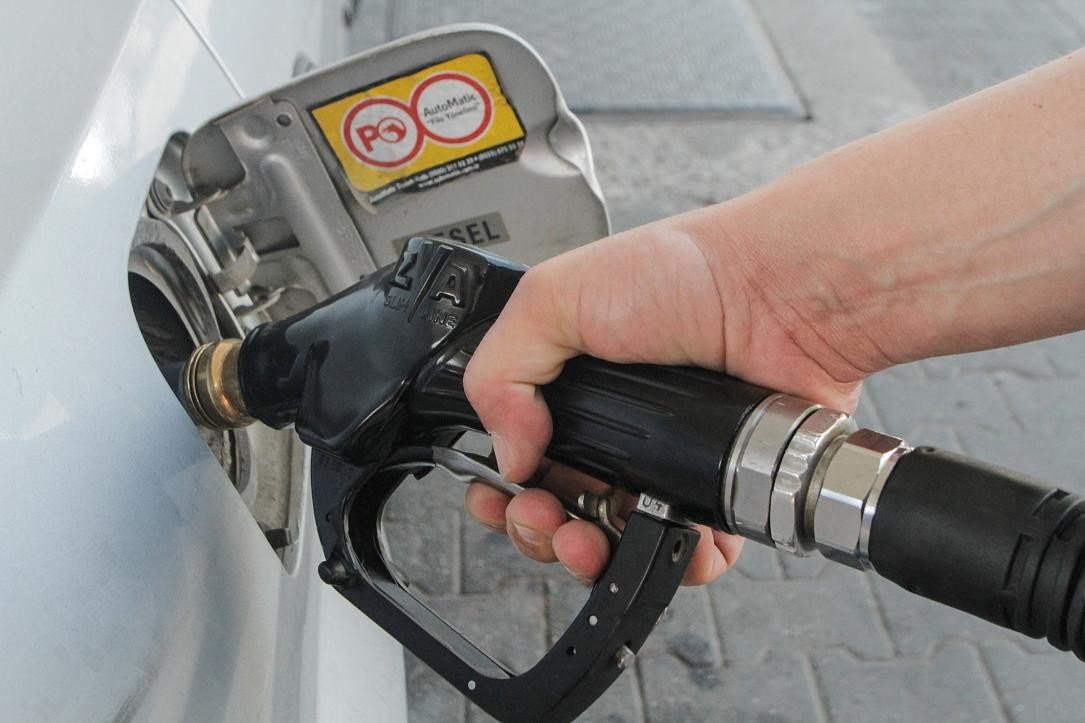 Hand holding diesel fuel nozzle refueling a car. Фото: Romania Insider