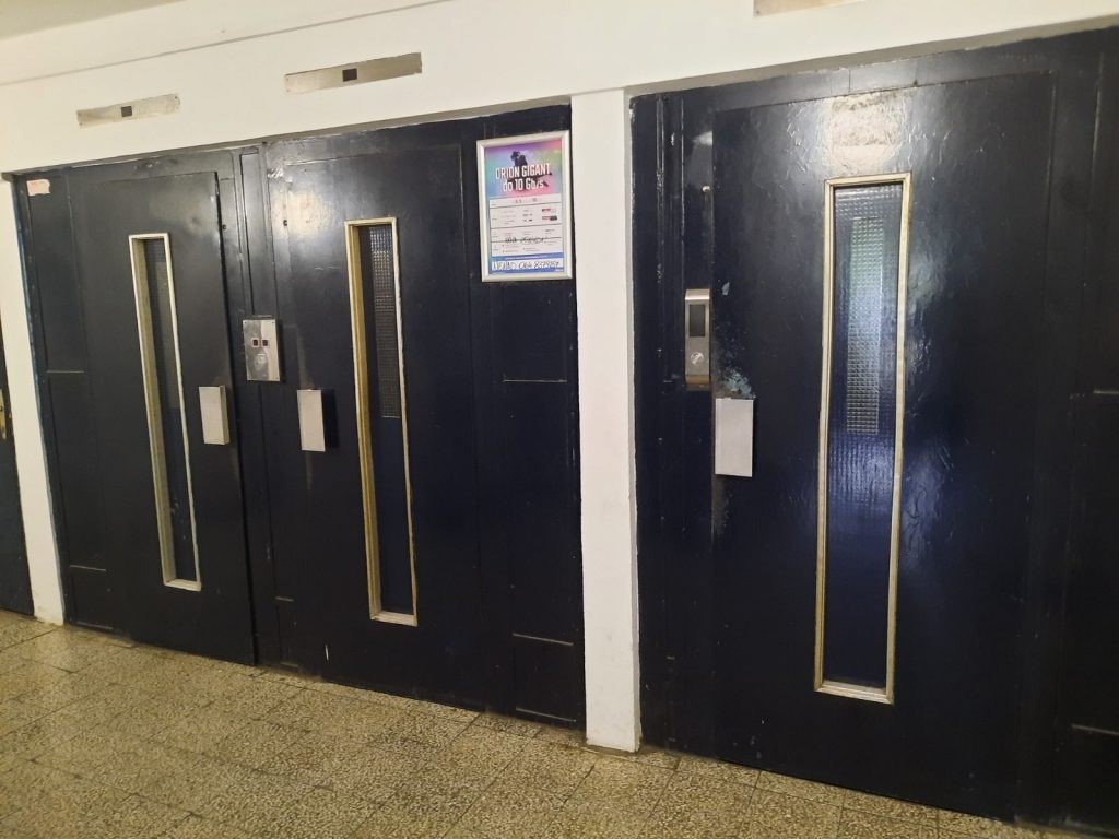 Потемневшие от времени двери лифтов в подъезде жилого дома в Белграде