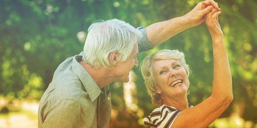 Пожилая пара танцует на природе в парке в солнечный день