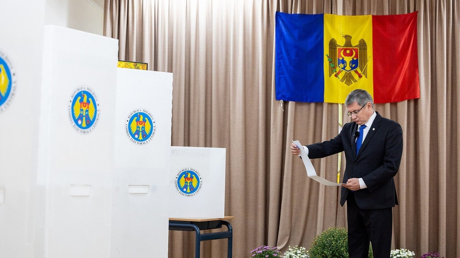 Спикер парламента Молдовы Игорь Гросу голосует на парламентских выборах в сентябре 2025 года на фоне государственного флага Молдовы