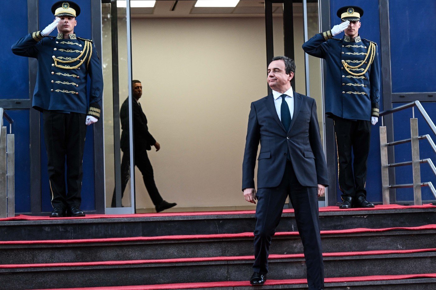 Альбин Курти спускается по лестнице правительственного здания в сопровождении почётного караула